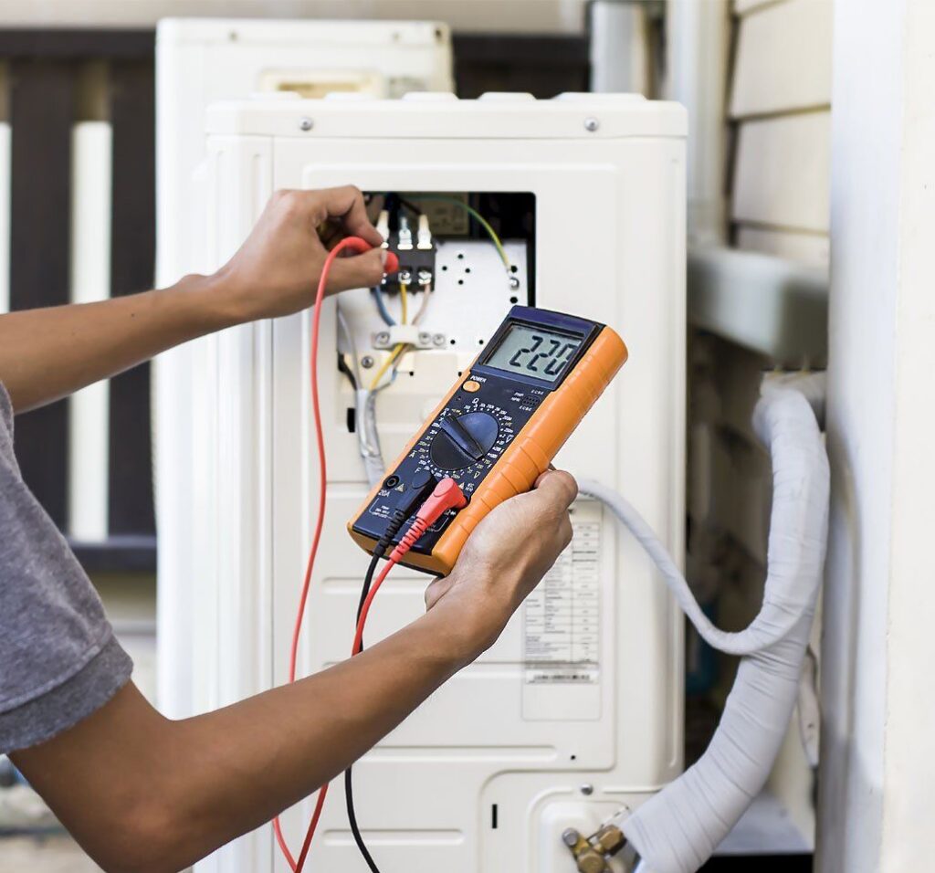 Technician checking voltage on AC unit