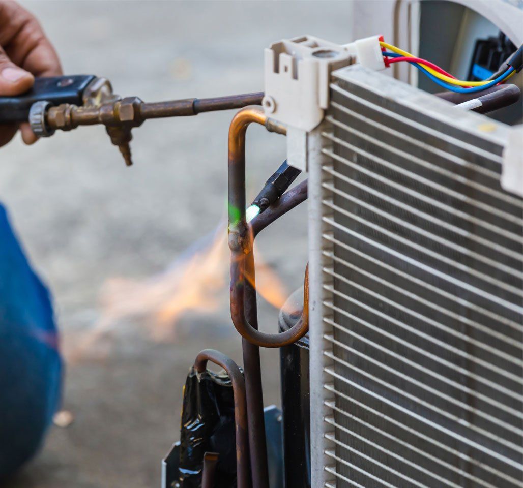 Technician from Climate Control Heating & Air Conditioning Inc reparing exterior AC unit